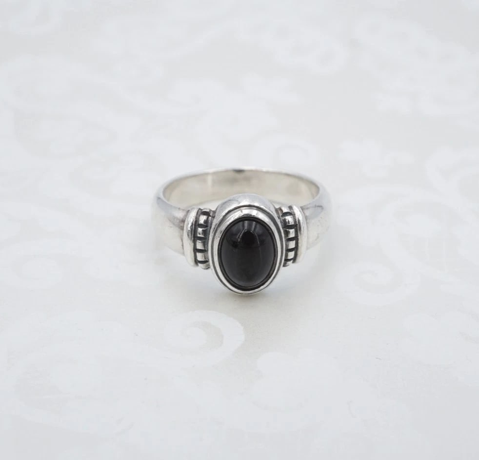James Avery Beaded Onyx Ring Sterling Silver Cabochon Size 6.5 Retired RS3804: This retired ring from James Avery features an onyx cabochon bezel set atop a slim sterling silver band with bead accents on either shoulder. Metal Type: Sterling Silver Notable Marks: JA Hallmark STE