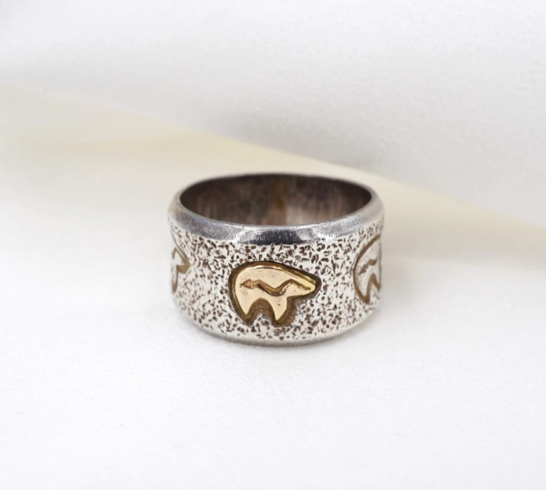 Al Joe Heartline Bear Ring Chunky Sterling Silver 14k Gold Sz 6.5 Navajo RS4079: This ring from Navajo artisan Al Joe features a wide sterling silver band embellished with continuous heartline bear motifs etched on the face. One of the bears is crafted in rich 14k yellow gold, pro