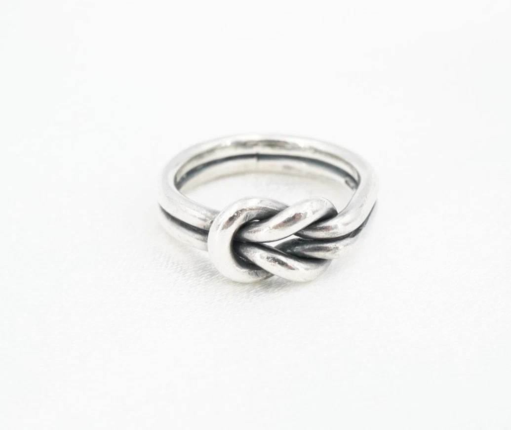 James Avery Lover's Knot Band Ring Sterling Silver Size 5 Retired RS4023: This retired James Avery "Lover's Knot" ring features a slim sterling silver band with an ornate, interlocking loop design in the center. The knot signifies two people have become one, bound together 