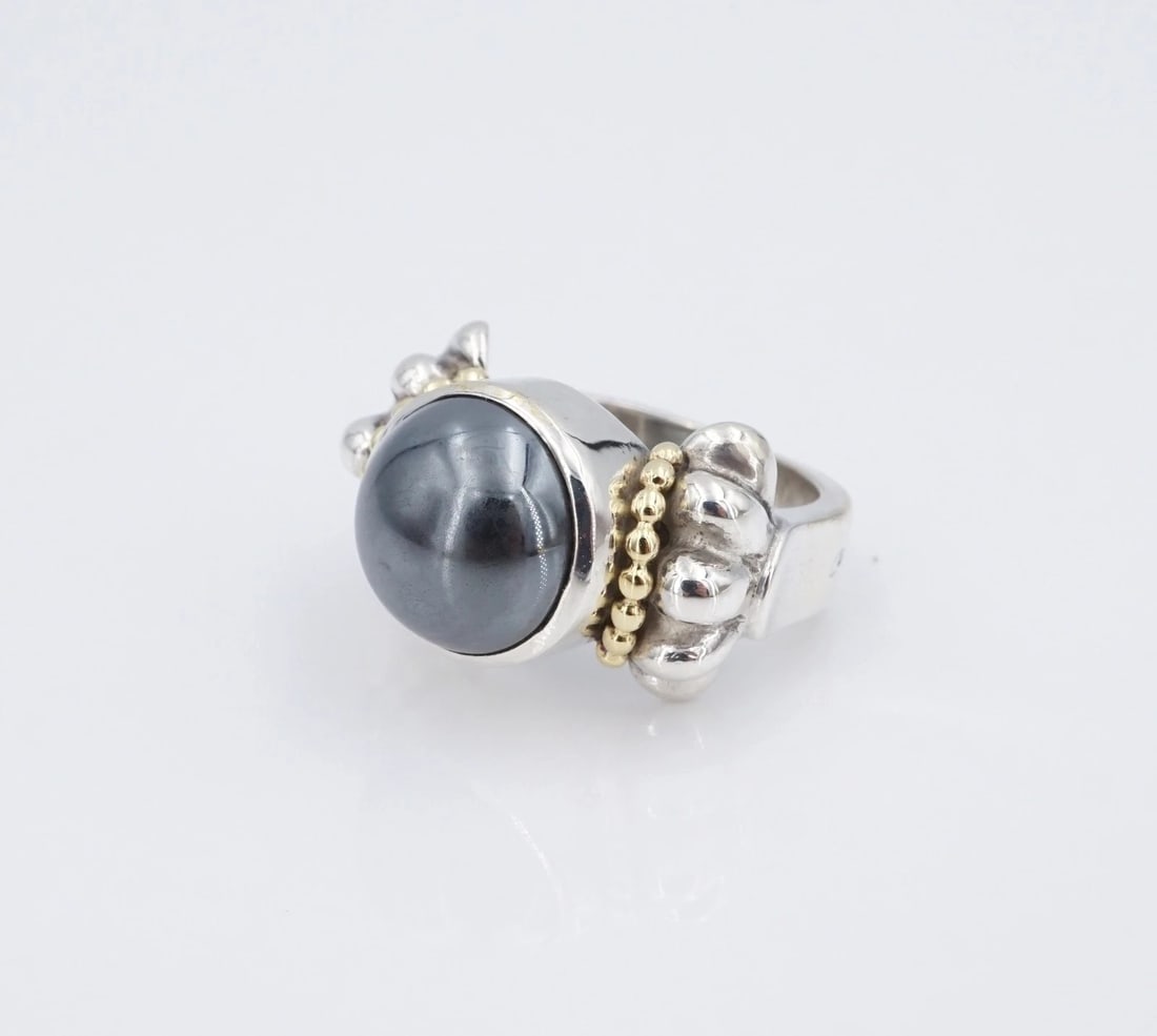 Lagos Caviar 2-Tone Hematite Ring Sterling Silver 18k Gold Sz 5.75 Chunky RS3966: This Lagos ring centers on a large hematite cabochon bezel set atop a wide sterling silver band with scalloped shoulders. Metal Type: Sterling Silver Notable Marks: Caviar 925 750 Measurements: Size 5