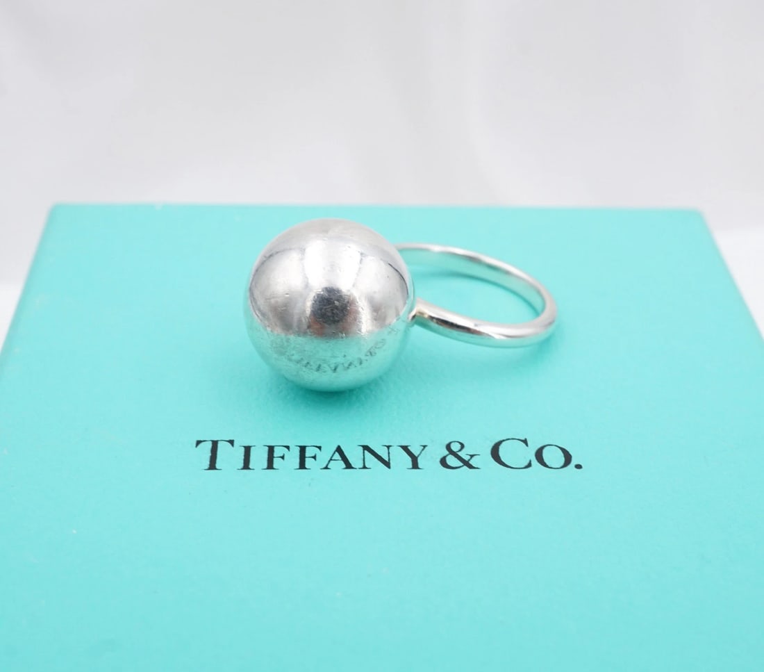 Tiffany & Co. Hardwear Ball Ring 15.7mm Sterling Silver Size 5.75 Retired RS4018: This retired Tiffany & Co. "Hardwear Ball" ring features a large sphere set atop a slim band, all crafted in solid sterling silver. Metal Type: Sterling Silver Notable Marks: Tiffany & Co 925 New York