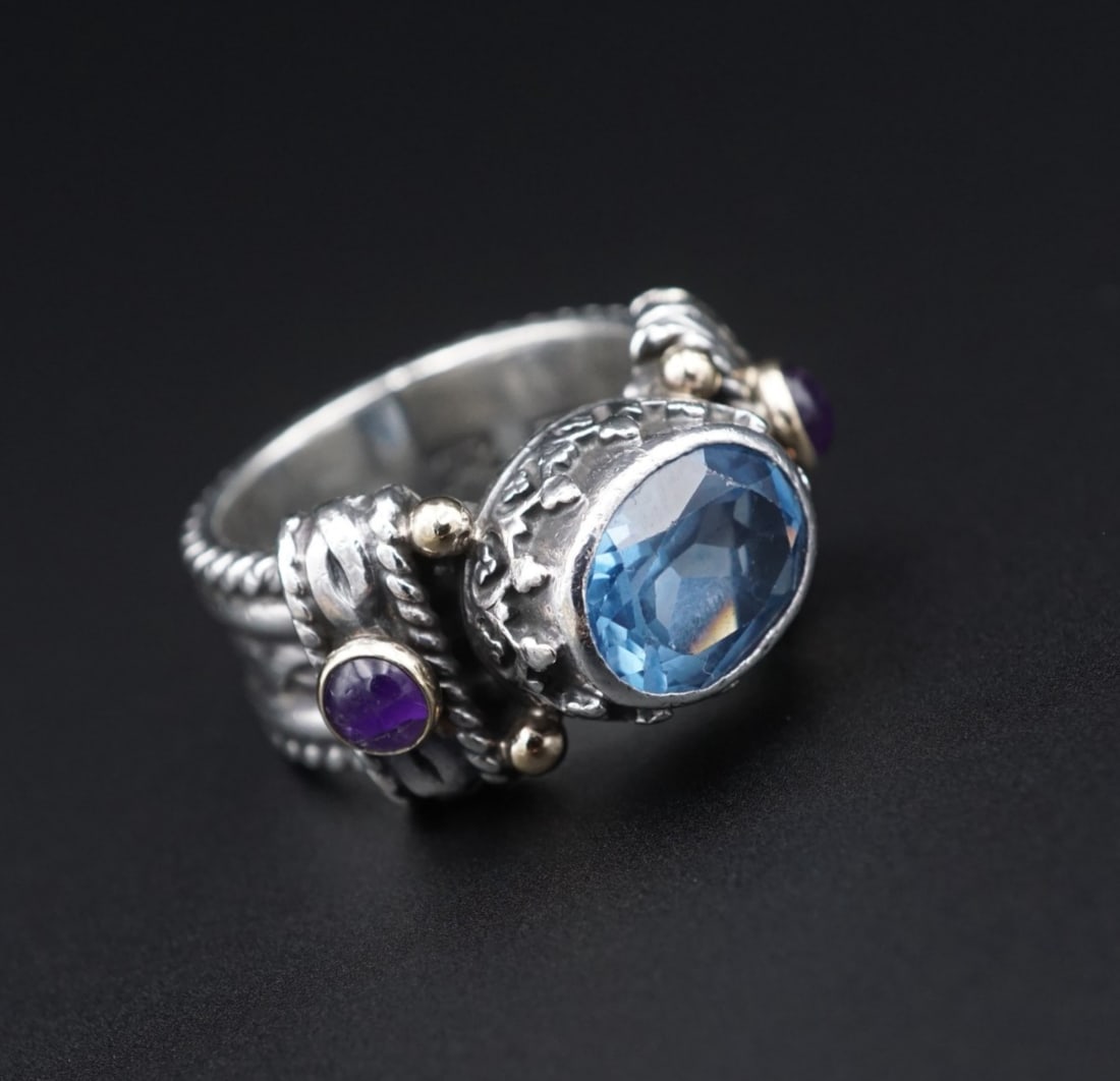 Reve Blue Topaz Amethyst Ring Sterling Silver 14k Gold Sz 6.25 Cocktail RS3779: This ring features a vivid blue, oval cut topaz bezel set atop a chunky sterling silver mount with amethyst cabochons on each shoulder. The shank is embellished with rope designs and 14k yellow gold b