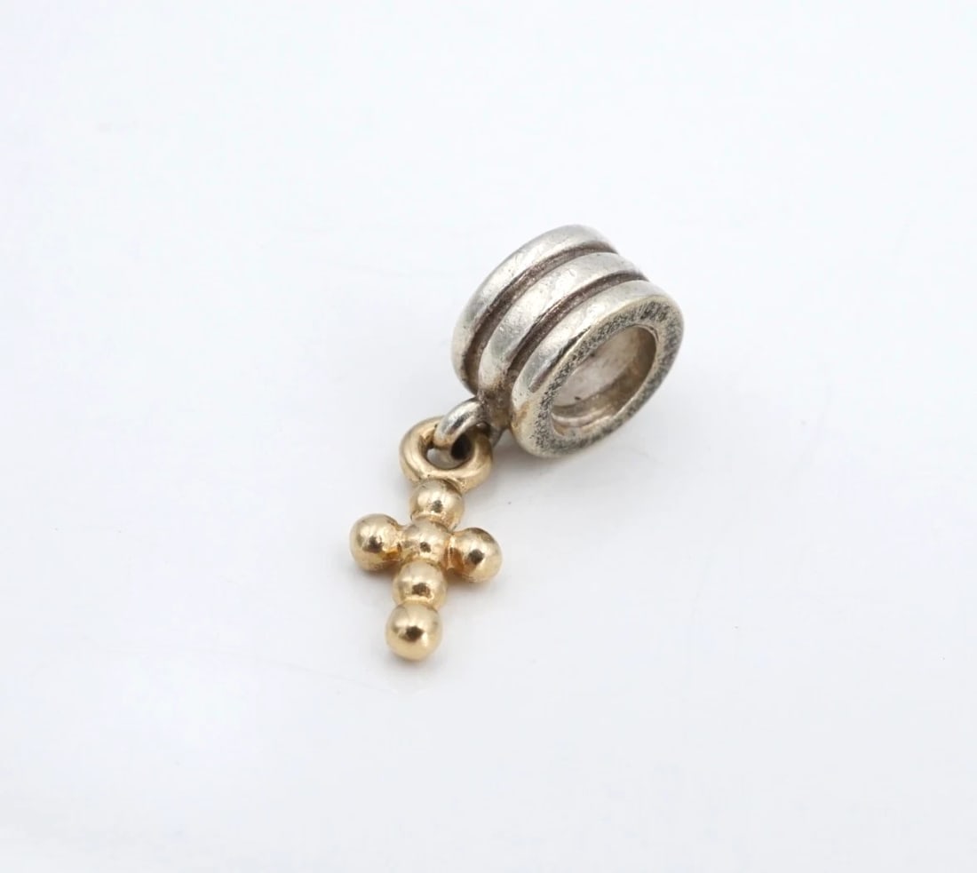 Pandora Beaded Cross Dangle Charm Sterling 14k Gold 0.75" 790169 ALE CHS2375: This retired Pandora charm features a textured sterling silver spacer bead with a beaded 14k yellow gold cross design dangling below. This sweet charm is a timeless accessory for yourself. Metal Type: