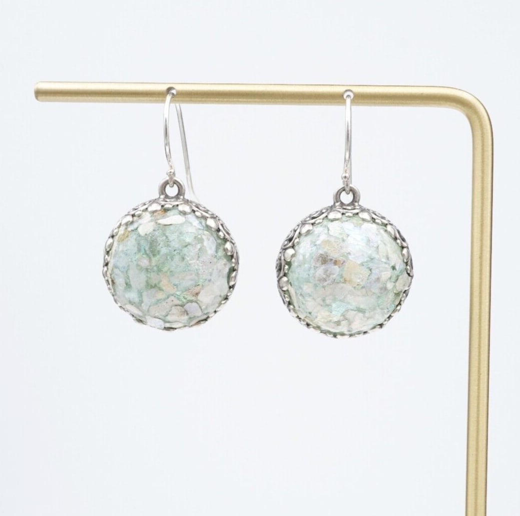 Vintage Roman Glass Earrings Sterling Silver Dangle Cabochon 1" Israel ES2567: This vintage pair of chunky earrings feature speckled blue Roman Glass cabochons, bezel-set in sterling frames with an intricate stamped border. The earrings hang from sterling hooks, giving them grea