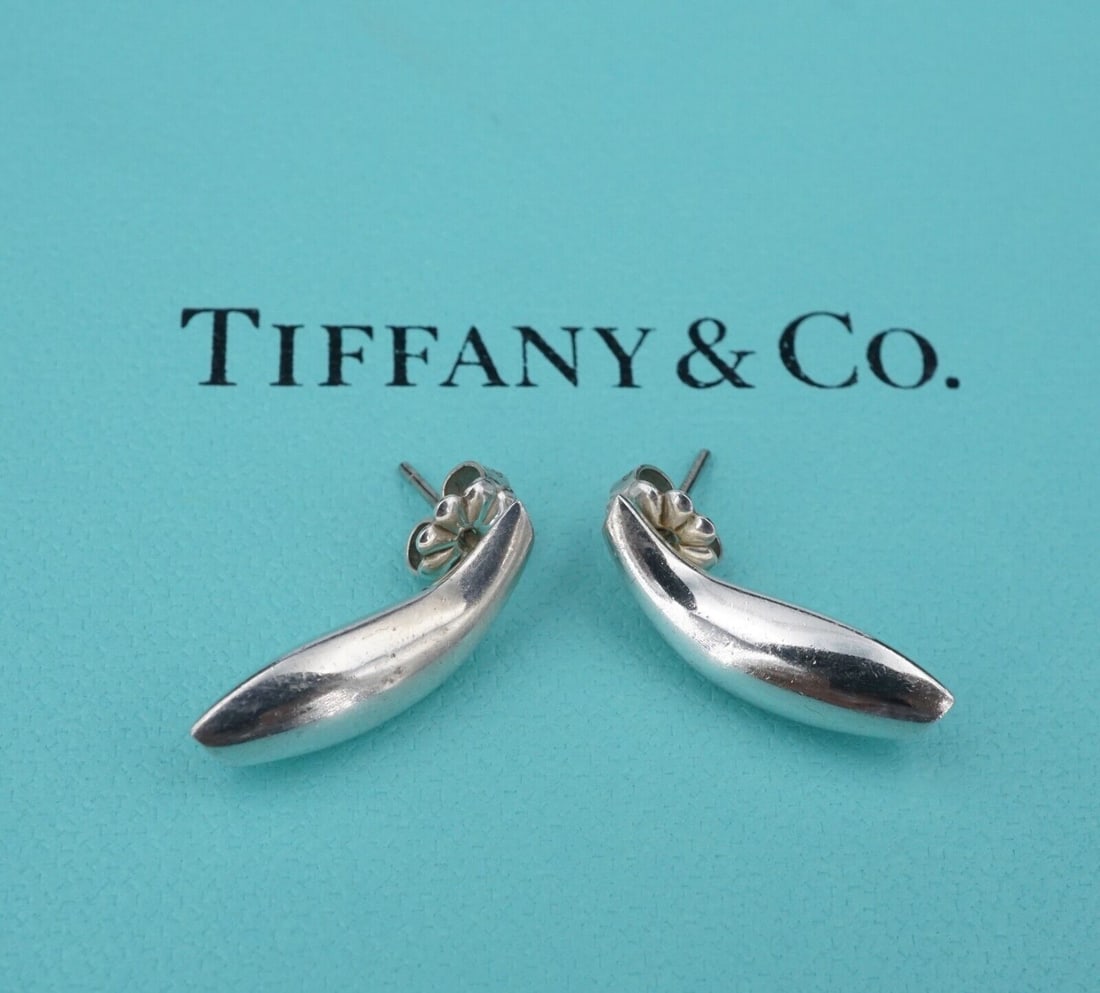 Tiffany & Co. Sterling Silver Earrings Curved Fish Stud Frank Gehry ES2458: These earrings are designed by iconic Tiffany & Co artist Frank Gehry. Featuring a curved design, these fluid earrings are a fun and elegant design. Metal Type: Sterling Silver (marked and tested) Not
