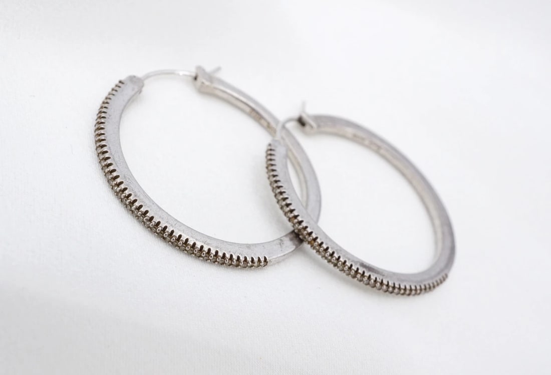 Estate Natural Diamond Hoop Earrings Sterling Silver 30mm Large HOB ES2864: These earrings from HOB feature a large, sterling silver hoop construction with an intricate set natural diamonds across the front. The earrings fasten securely with sterling silver lever-backs. Metal