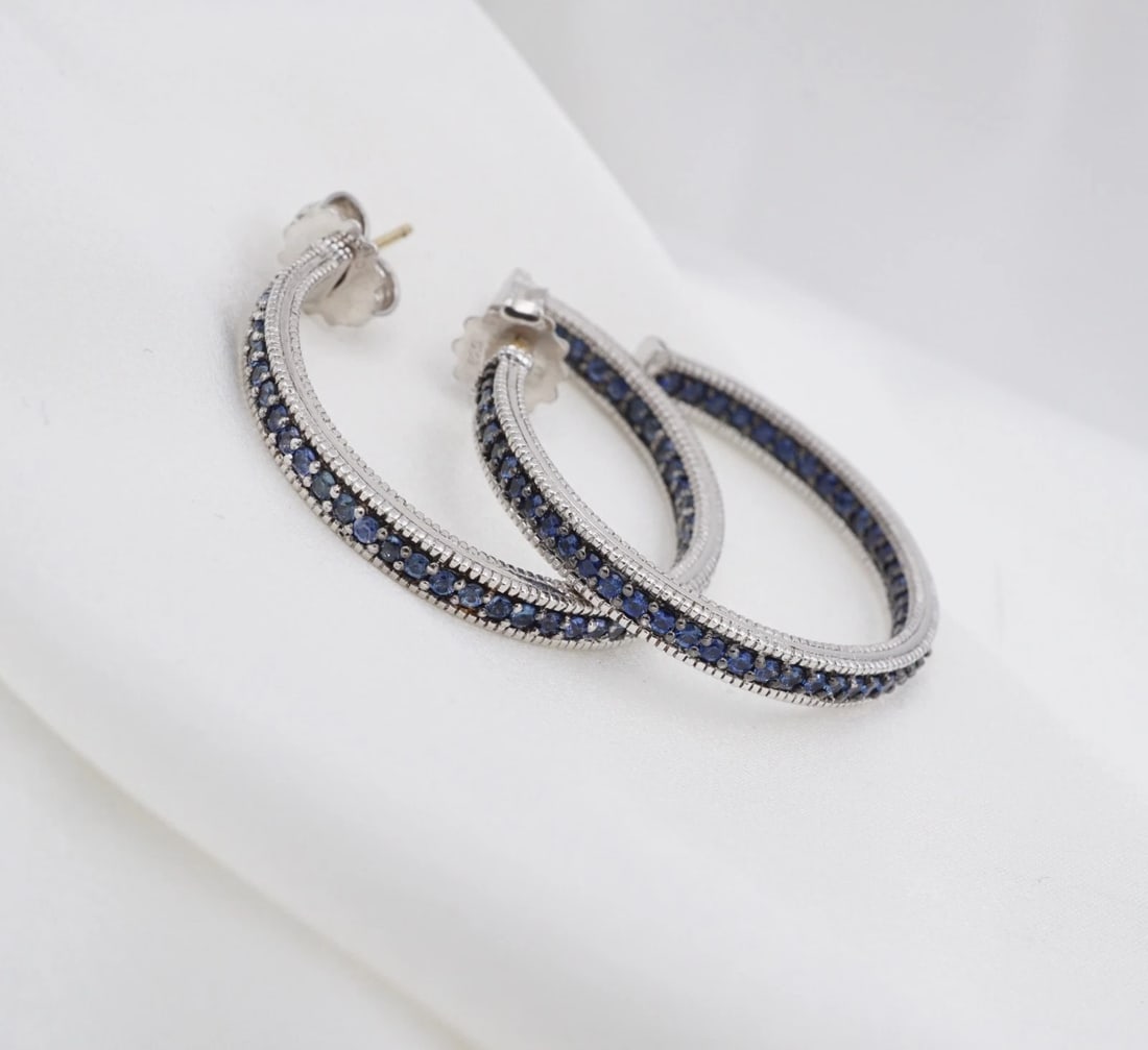 Judith Ripka Blue Sapphire Inside Out Hoop Earrings Sterling Silver 1.3" ES2926: These earrings from Judith Ripka feature a large sterling silver hoop embellished with a line of natural round blue sapphires down the front and inside back of the earrings for maximum sparkle. Metal 
