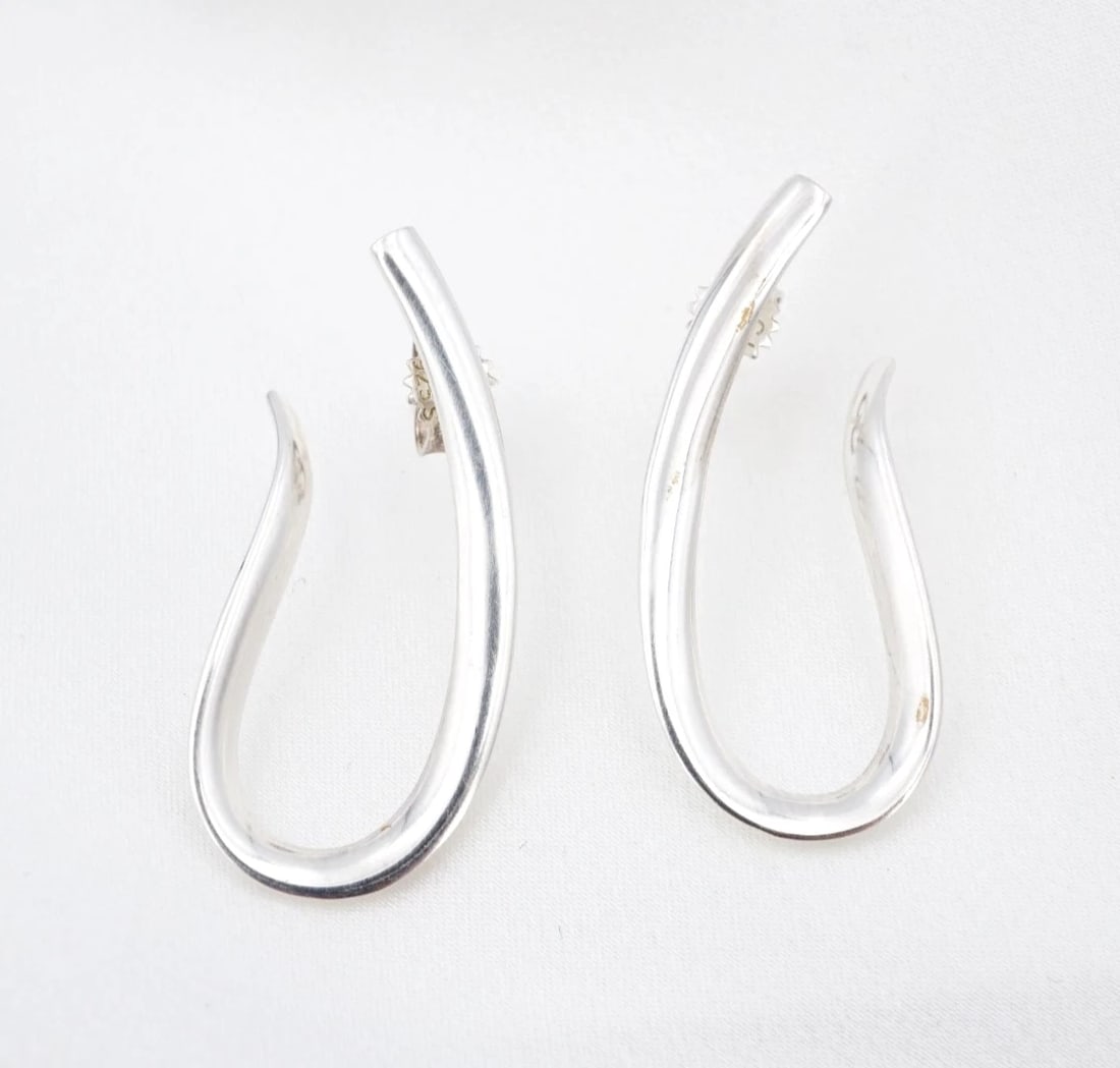 Georg Jensen x Regitze Overgaard Infinity Earrings Sterling Silver 1.3" ES2863: These Georg Jensen "Infinity Earrings" by designer Regitze Overgaard feature an elongated, sterling silver hoop design that gently curves into the shape of an ear. Metal Type: Sterling Silver Notable 