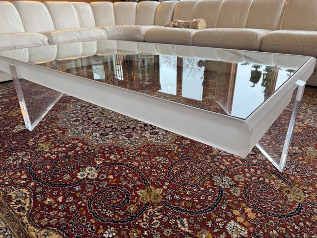 Mid-Century Modern Lucite and Glass Coffee Table: A sleek Mid-Century Modern coffee table featuring a thick rectangular glass top set into a Lucite frame with angular Lucite legs. The minimalist design and transparent construction give this piece a s