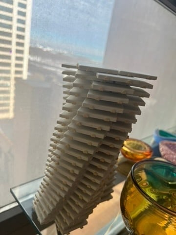 Tessellated Tile Sculpture Modern Geometric Art with a Twisting Design: Discover the intricate beauty of this tessellated tile sculpture, featuring stacked white tiles in a twisting geometric pattern. A striking piece of modern art perfect for design inspiration and archi