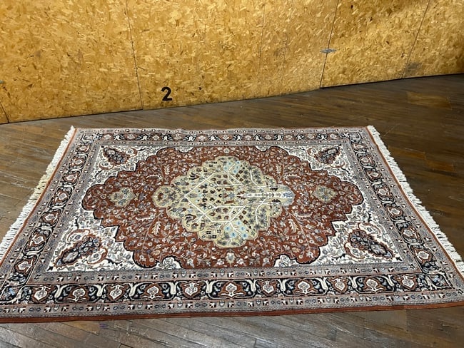 Handmade Persian-Style Wool Rug 6.5x4.5 ft Medallion & Floral Motif: A finely woven Persian-style wool rug featuring a central medallion design with intricate floral and vine motifs. The rug presents a warm terracotta-red field surrounded by cream and navy borders with