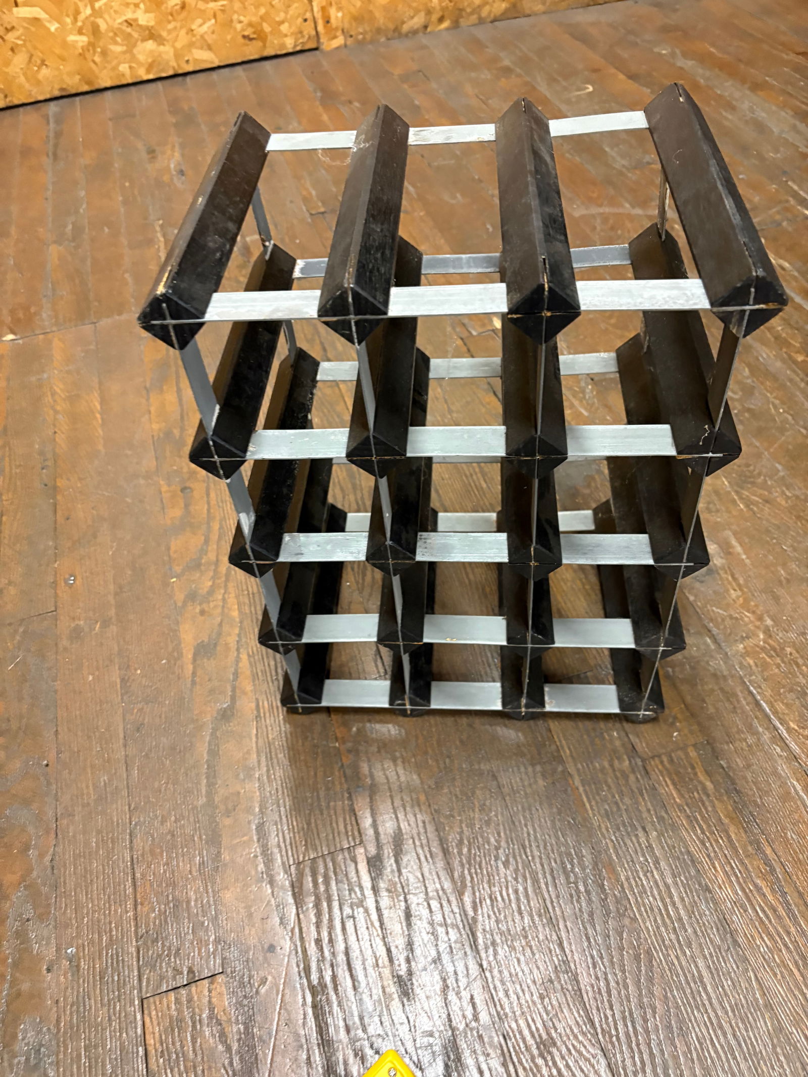 Modern Black Metal Wine Rack | Modular Grid Bottle Holder | Contemporary Bar Storage: Sleek modern black metal wine rack featuring a geometric grid design that securely stores multiple bottles horizontally. Constructed from metal with a matte black and gray finish, this modular-style r