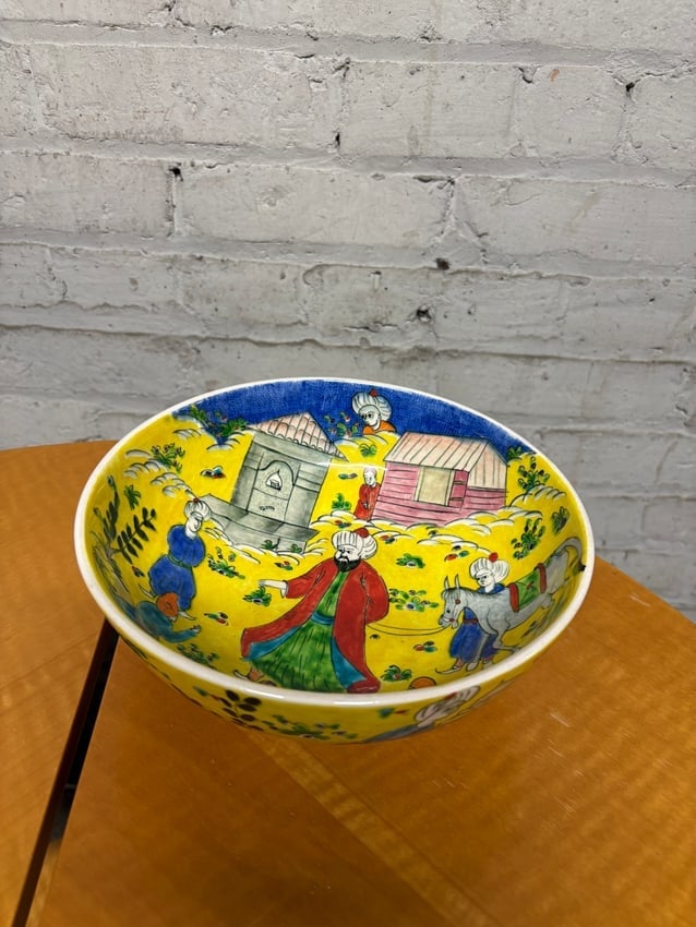 Hand-Painted Turkish Kutahya Pottery Bowl with Folk Scene – Signed Efsan Altonya: Vibrant hand-painted Turkish Kutahya pottery bowl depicting a lively village scene with figures, donkeys, and houses under a bright yellow sky. The exterior is decorated with additional figural and fl
