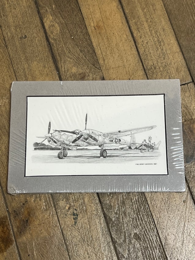 P-38 Lightning WWII Aircraft Print by P.J.M. Dewey Davidson, 1989: A detailed black-and-white print of the Lockheed P-38 Lightning aircraft, rendered by artist P.J.M. Dewey Davidson in 1989. This aviation artwork captures the iconic twin-boom design of the WWII fight