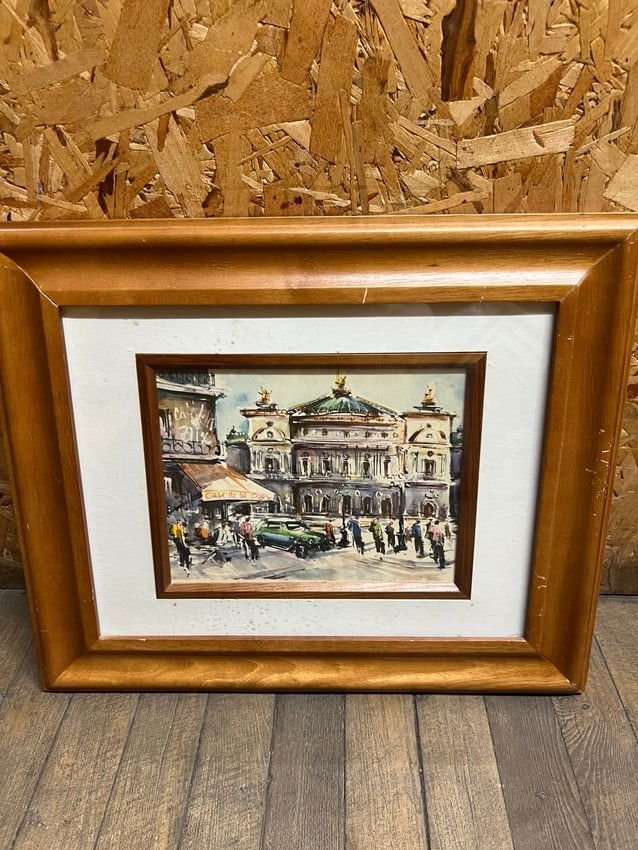 Framed Watercolor Painting Paris Street Scene with Cafe & Opera House: A charming framed watercolor painting depicting a bustling Paris street scene with figures, cars, and the iconic architecture of the Palais Garnier Opera House. The lively atmosphere includes a cafe t