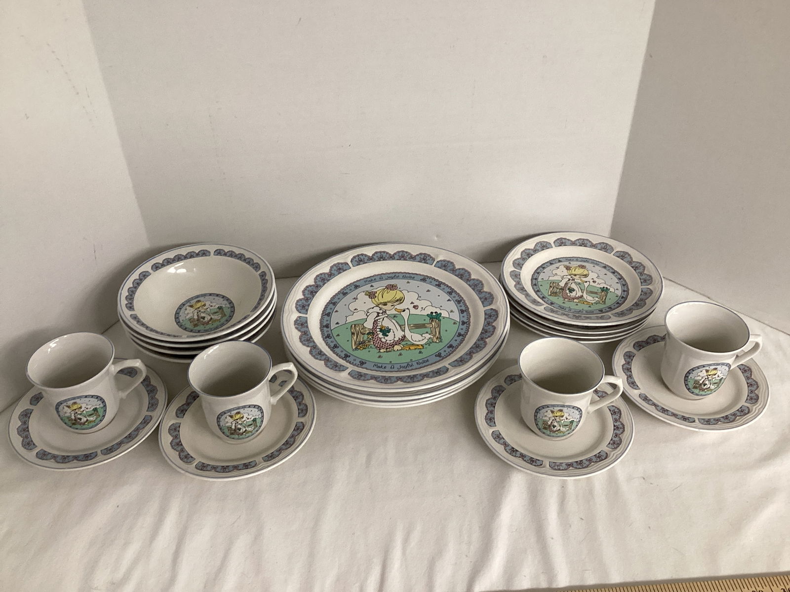 20 Pieces 1992 Precious Moments Make a Joyful Noise Dinnerware: Four each - 10 1/2" dinner plate, 7" bowl, 7 1/2" salad plate (one chipped), cups, and 6 1/2" saucer