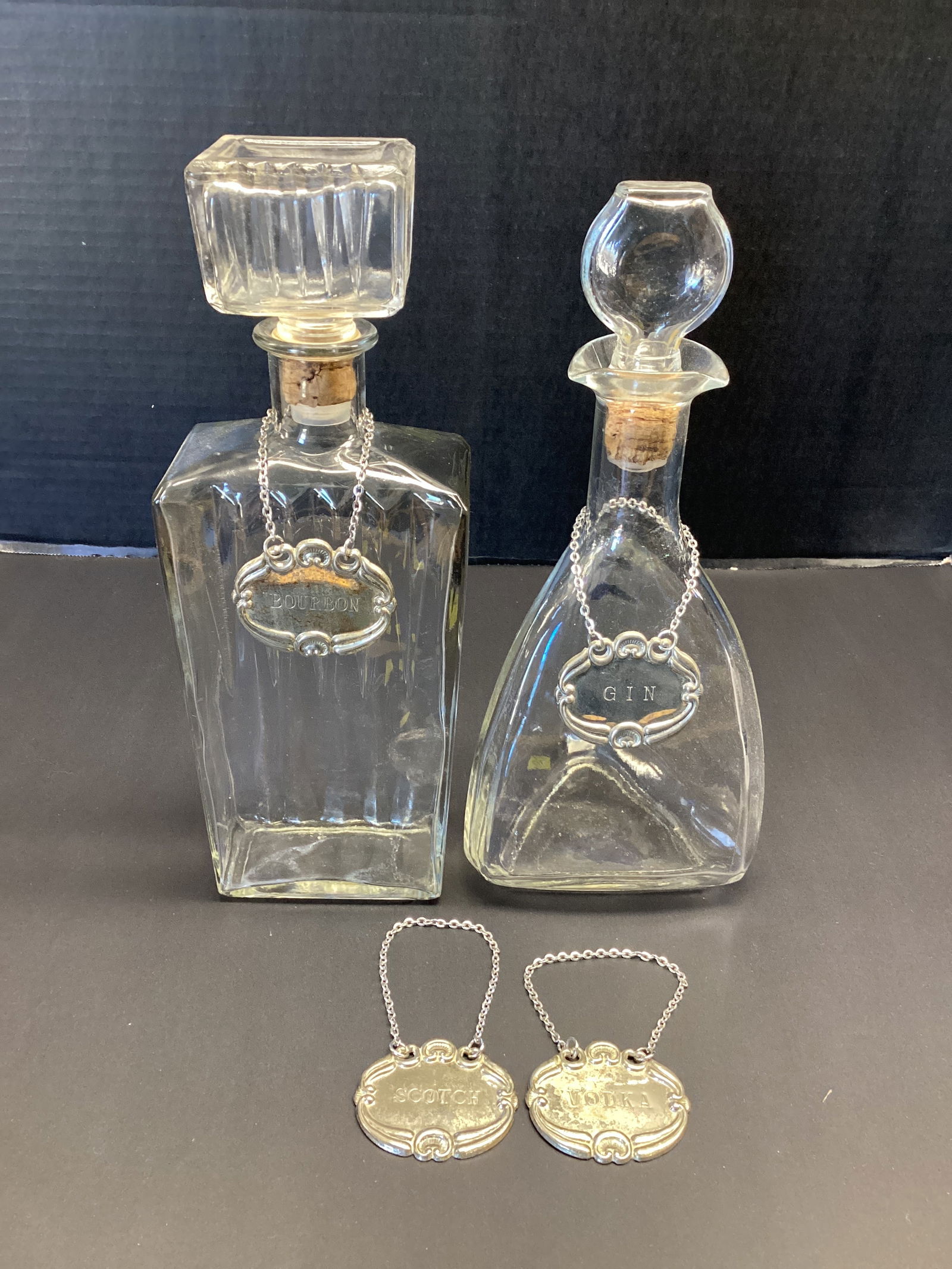 Two Vintage Glass Liquor Decanters with Four Hanging Labels: 11" and 11 1/2" h 
