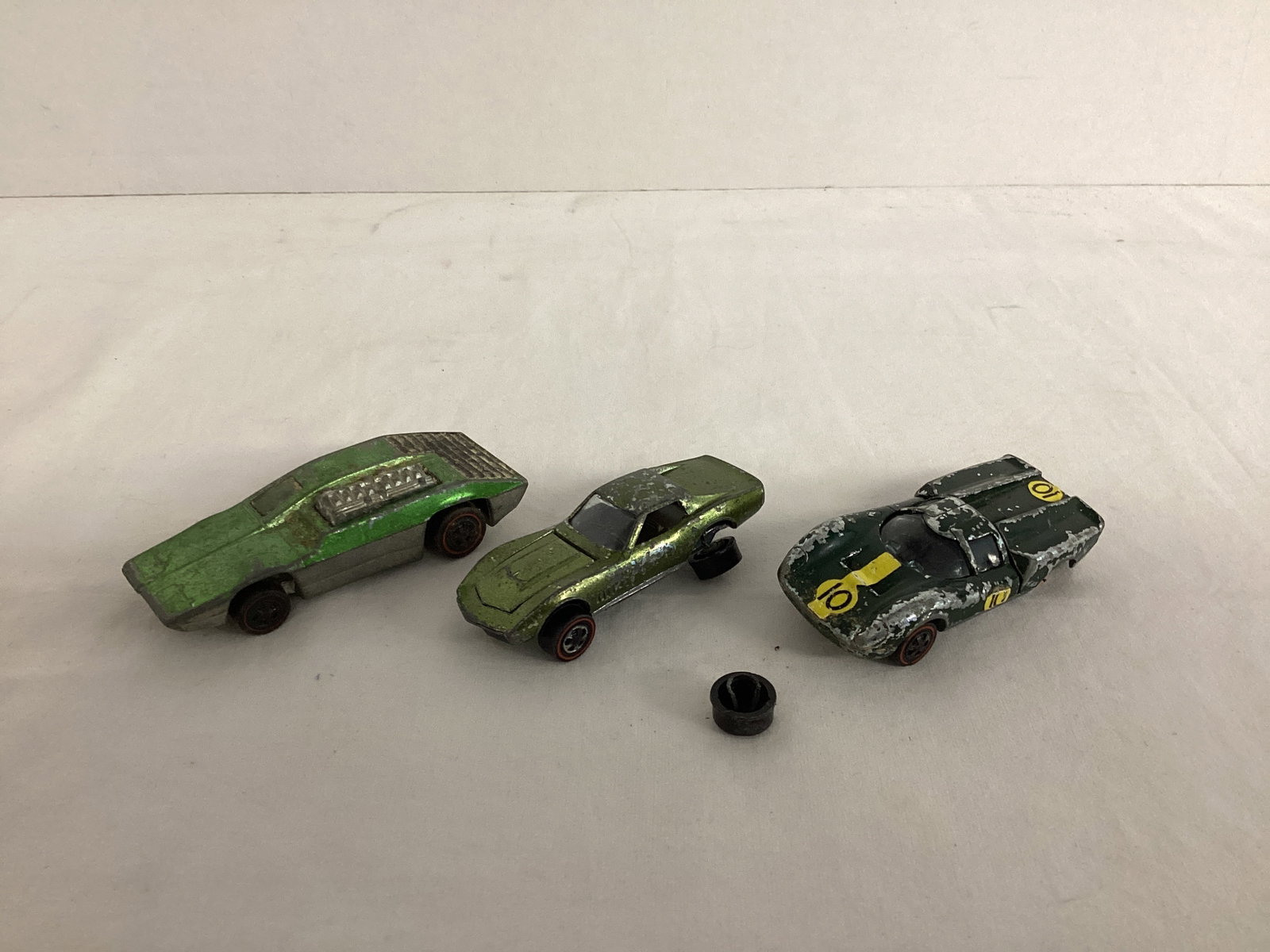 Three Redline Hot Wheels Cars: two are missing wheels, all have wear