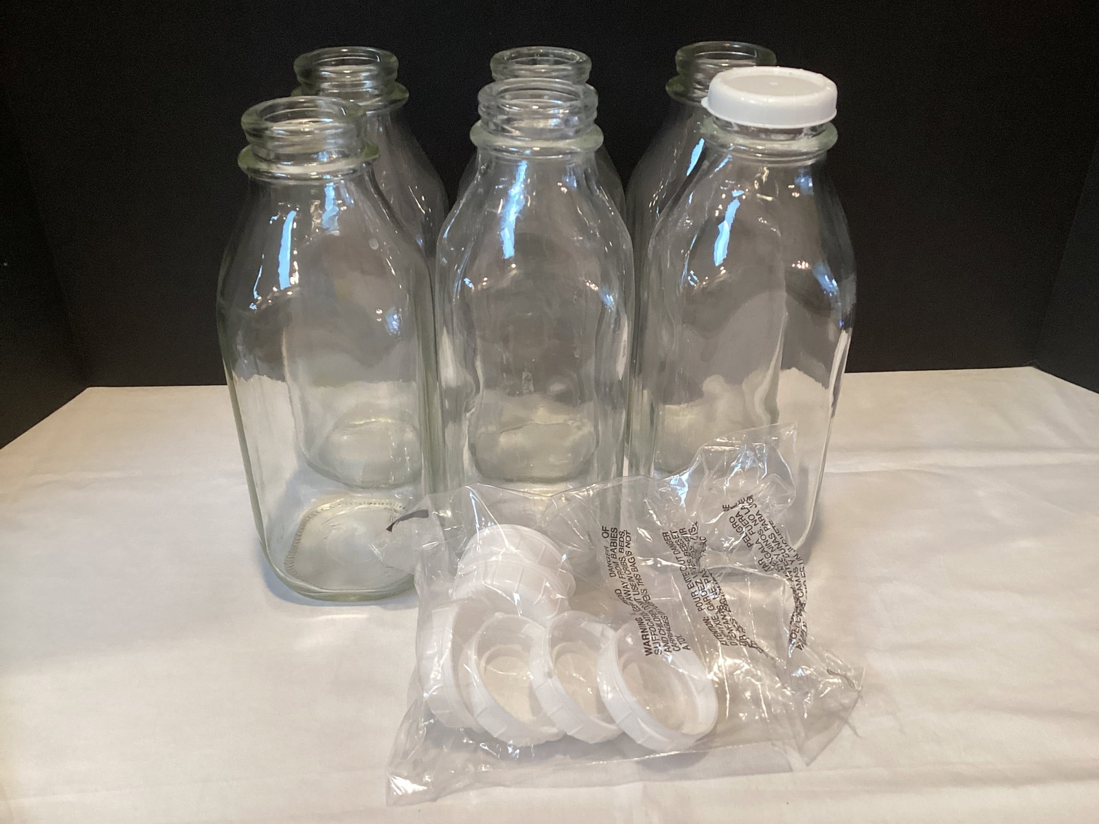 Six Glass Milk Bottles with Caps: 8 3/4" h