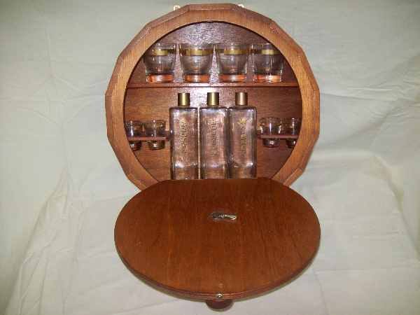 Decanter: Decanter set with barrel shape wall shelf, 3 bottles, 4 glasses & 4 shot glasses. Shelf measures 17 1/2 diam