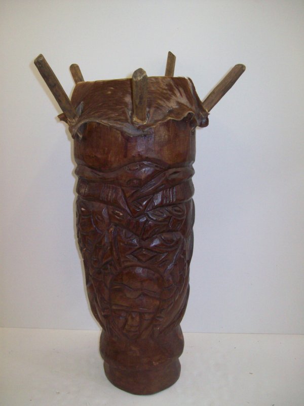 AFRICAN DRUM: AFRICAN DRUM. LACKING PIECE; REPAIRED; SCRATCHES. 25 INCHES HIGH X 8 INCHES WIDE