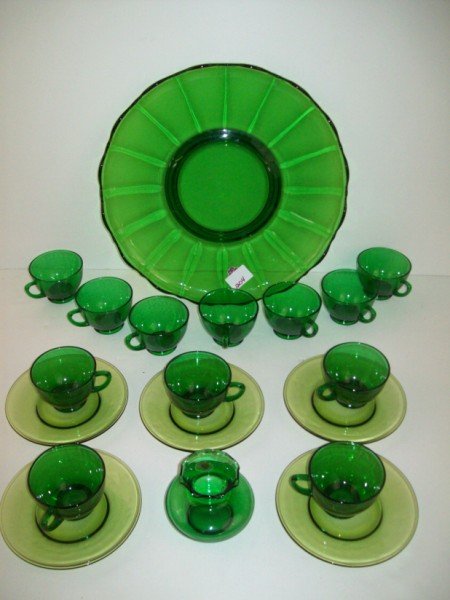 GREEN GLASS LOT: GREEN GLASS CUPS, PLATTER, SAUCERS. LARGEST MEASURES 14 INCHES DIAM