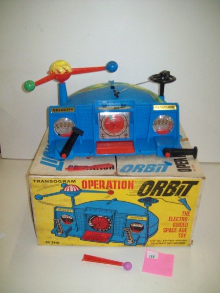 ORBIT TOY: ORBIT THE ELECTRO GUIDED SPACE AGE TOY BY TRAUSY KING OF TOYS. LACKING ROCKET TOP PART BROKEN. WEAR; USED CONDITION. 19 INCHES WIDE X 10 INCHES HIGH
