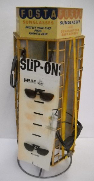 ADVERTISING: FOSTA SUNGLASSES METAL ROTATING DISPLAY WITH SOME LURAL SUNGLASSES. RUST; STAINED; USED CONDITION. 31 INCHES HIGH X 12 1/2 INCHES WIDE