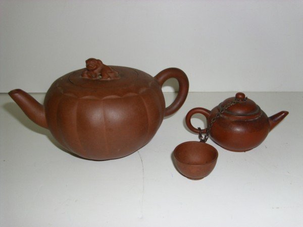 YIXING TEA POT: CLAY YIXING TEA POTS. MINIATURE WITH CUP. NEEDS CLEANING; MINOR CHIPS. LARGEST MEASURES 6 1/2 INCHES WIDE X 3 INCHES HIGH. CALL 845-457-7550 OR EMAIL STERLINGAUCTION@AOL.COM FOR FULL CONDITION REPORT,