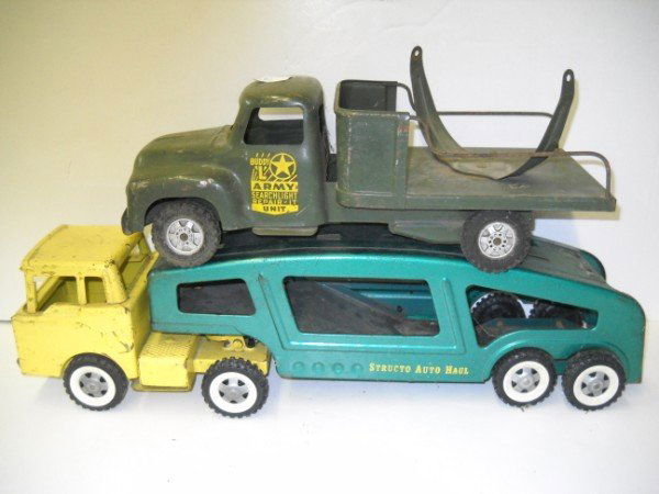 TIN TRUCKS: 2 TIN TRUCKS INCLUDING STRUCTO AUTO HAUL & BUDDY L ARMY SEARCH LIGHT TRUCK. LACKING PIECES; PAINT LOSS; RUST; SCRATCHES. LARGEST MEASURES 21 INCHES X 5 INCHES.