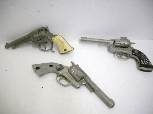 TOY GUNS: 3 TOY GUNS INCLUDING 1 GENE AUTRY; 2 MARSHALL. USED CONDITION; 1 LACKING GRIPS; 1 CHAMBER NEEDS FIXING. LARGEST MEASURES 10 INCHES X 5 INCHES