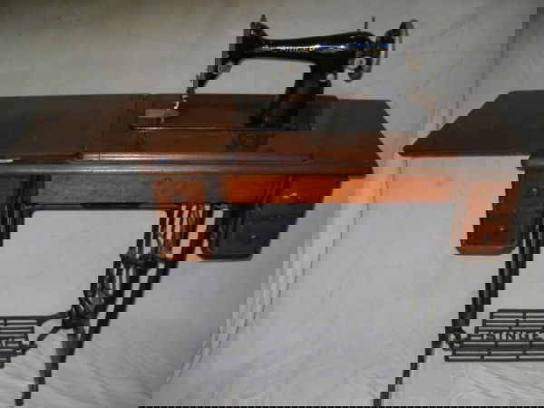 SINGER SEWING MACHINE: 1920'S SINGER PEDAL SEWING MACHINE. 34 INCHES X 30 INCHES. DUE TO THE SIZE OF THIS ITEM IT IS TOO LARGE FOR SHIPPING, PLEASE CONTACT AUCTION HALL PRIOR TO BIDDING.