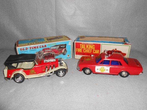 TOYS: 2 TOY CARS INCLUDING BATTERY OPERATED OLD TIME CAR & FRICTION POWERED TALKING FIRE CHIEF CAR. 1 LACKING BATTERY COVER; BOXES WORN. LARGEST MEASURES 11 INCHES X 4 INCHES.