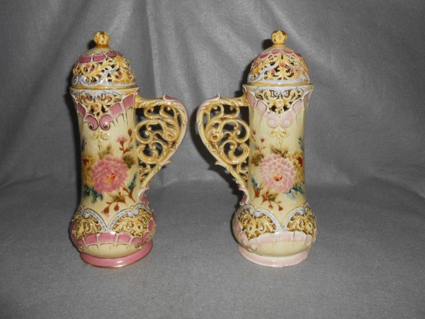 ZSOLNAY: 2 ZSOLNAY COVERED HANDLED VASES. 1 LID REPAIRED; CHIPS TO BASE. 10 INCHES X 6 1/2 INCHES.