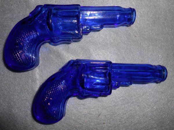 CANDY DISPENSER: 2 BLUE GLASS GUN SHAPED CANDY DISPNSERS. 5 1/2 INCHES.