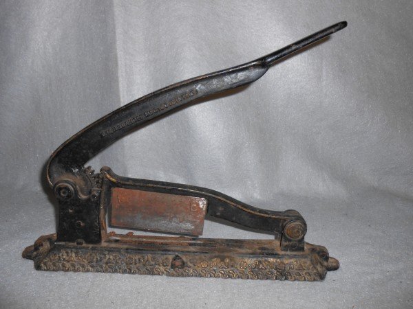 TOBACCO CUTTER: TOBACCO CUTTER MARKED THE BRUNHOFF MFG. CO. RUST; USED CONDITION. 17 INCHES X 6 INCHES.