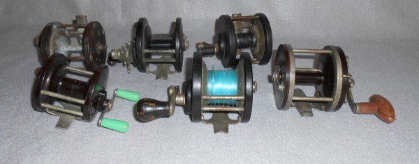FISHING REELS: 6 FISHING REELS INCLUDING PENN NO. 77; PENN DELMAR NO. 285; OCEAN SIDE REGAL; LIVE WIRE SURF REEL. CRACK; RUST; USED CONDITION.