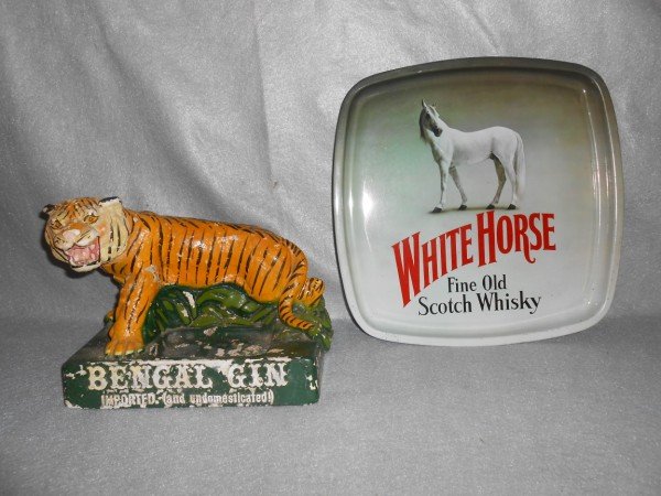LIQUOR ADVERTISING: 2 PIECES LIQUOR ADVERTISING INCLUDING WHITE HORSE SCOTCH WHISKY SERVING TRAY; & BENGAL GIN BOTTLE HOLDER. PAINT LOSS; SCRATCHES. LARGEST MEASURES 9 INCHES X 7 INCHES.