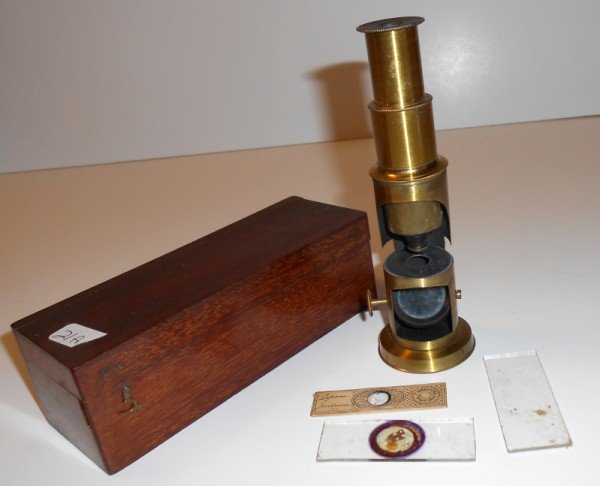 MICROSCOPE: SMALL BRASS MICROSCOPE WITH CASE. COVER NEED REPAIR; USED CONDITION. 6 1/2 INCHES X 2 1/2 INCHES.