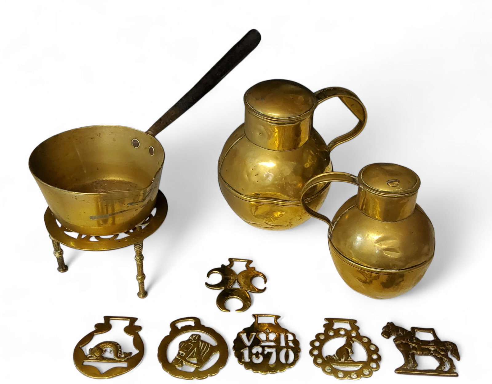 Metal Ware - a brass open saucepan, steel handle, 17cm diam; a trivet; two graduat: Metal Ware - a brass open saucepan, steel handle, 17cm diam; a trivet; two graduated Jersey jugs; six horse brasses