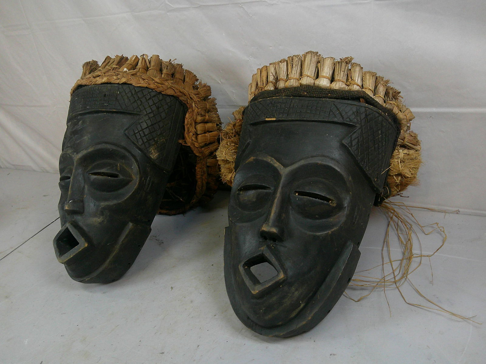 Pair of Hand Carved Wooden and Straw African Masks: Pair of Hand Carved Wooden and Straw African Masks