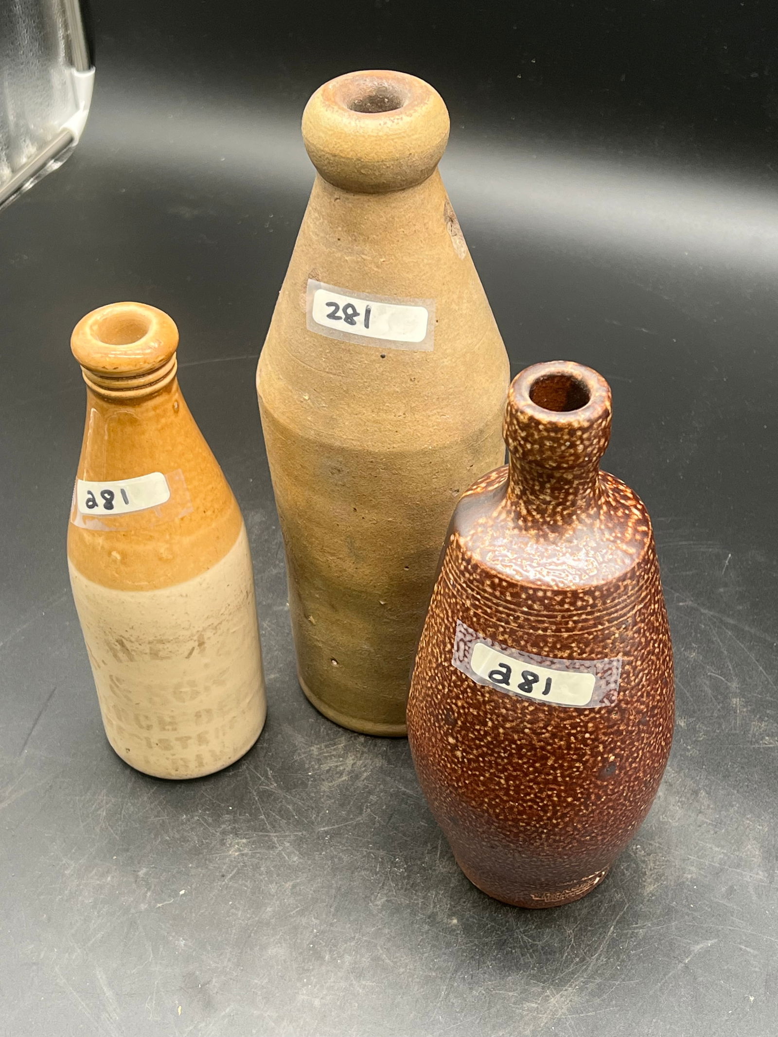 Lot of 3 Stoneware Bottles: Lot of 3 Stoneware Bottles. One has advertisement on it (83,90,98)