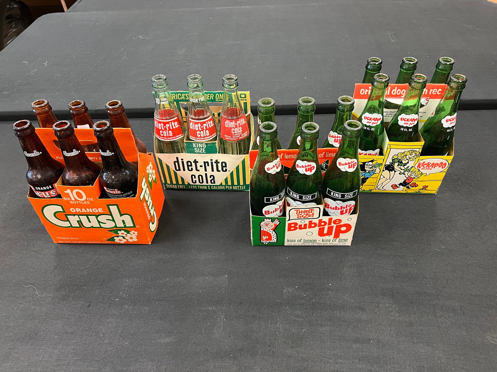 Lot of 4 Early 6 Packs of Bottles: Lot of 4 Early 6 Packs of Bottles. 6 pack of Crush, 3 pack Diet Rite Cola , 6 pack of Kickapoo Joy Juice, and 6 pack of Bubble Up Cola. All in cardboard sleeves.