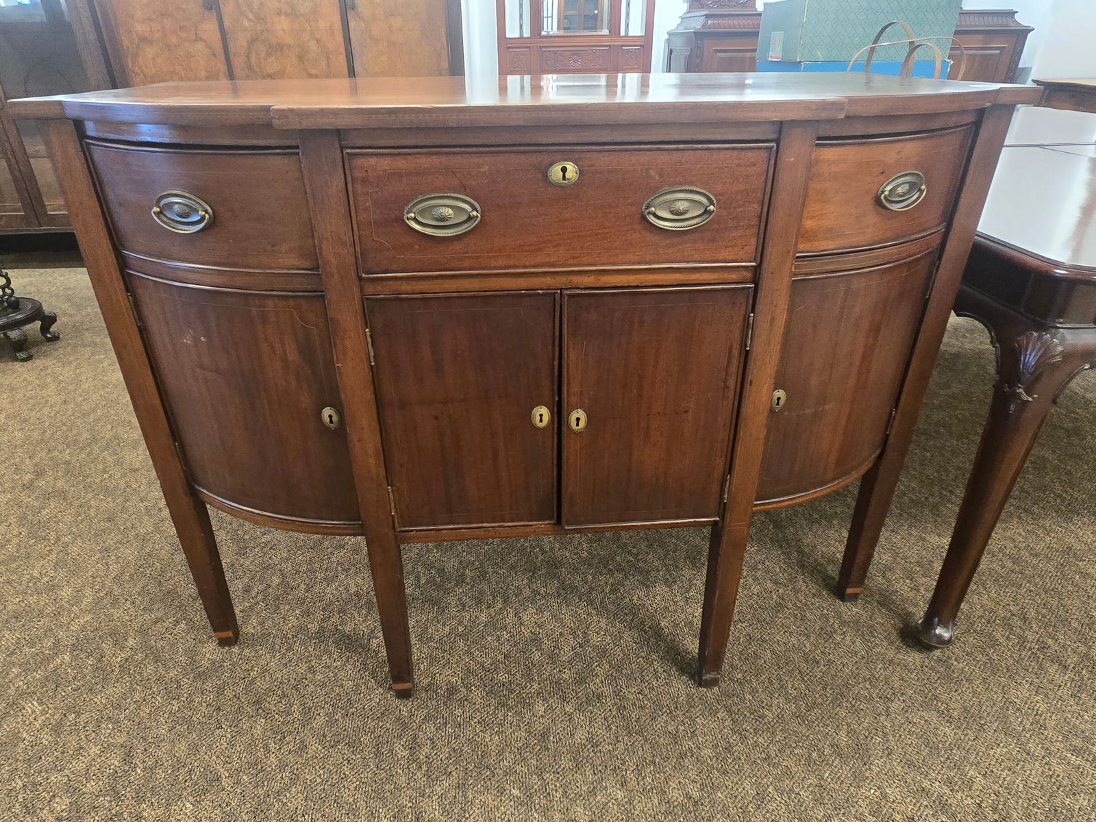 Period Hepplewhite Mahogany Sideboard: Period Hepplewhite Mahogany Sideboard. Tapered legs. Brass handles banded inlay front. original finish and boards. Bow front.