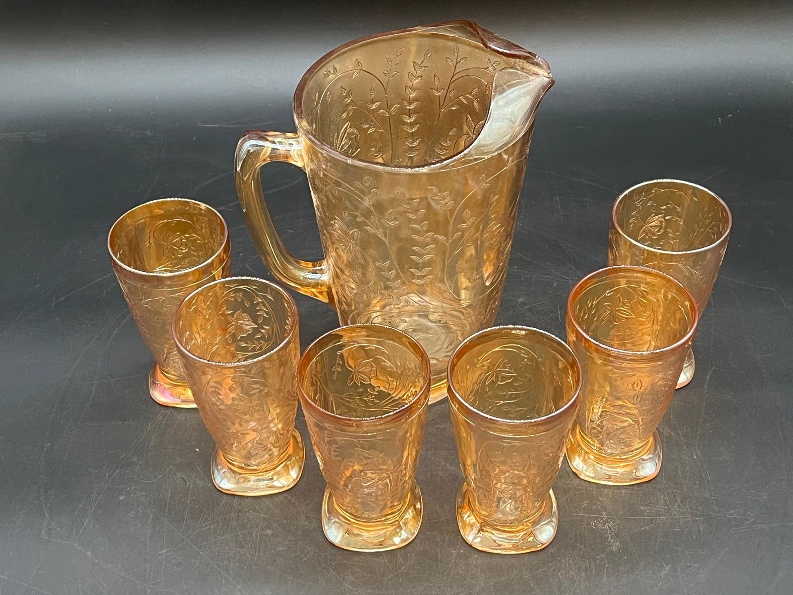 7 pc. Carnivaql Glass Water Set: 7 pc. Carnivaql Glass Water Set. Jeanette Floragold - Iridescent Pattern. Consists of 6 footed tumblers and 1 pitcher