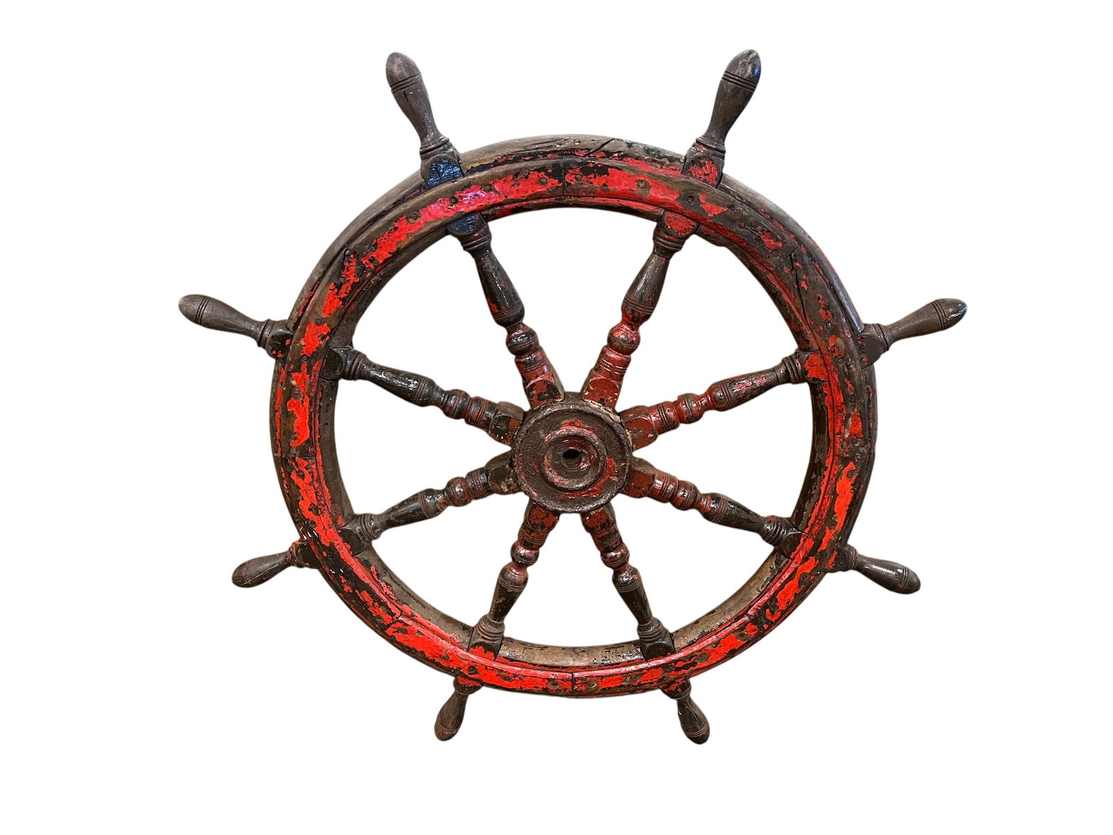 Ship Wheel: This item is a decorative wooden ship's wheel with a rustic, distressed red painted finish. [1, 2]Design & Materials: It features a traditional design with turned wooden spokes and is often constructe