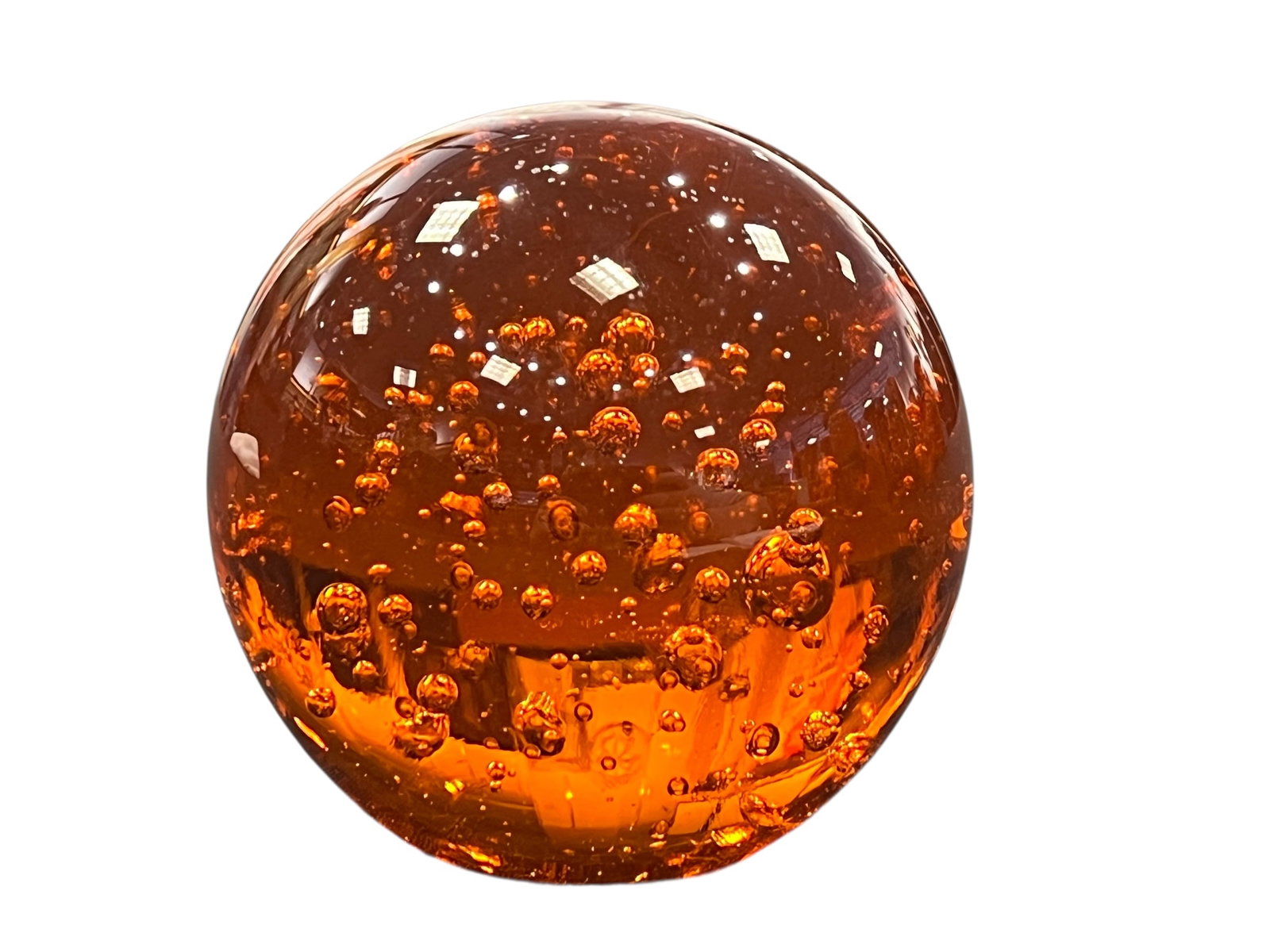 vintage amber art glass sphere paperweight: This object is a vintage Murano-style controlled bubble art glass sphere, often utilized as a decorative desk paperweight or orb. It features a deep amber or golden honey coloration. The trapped air p