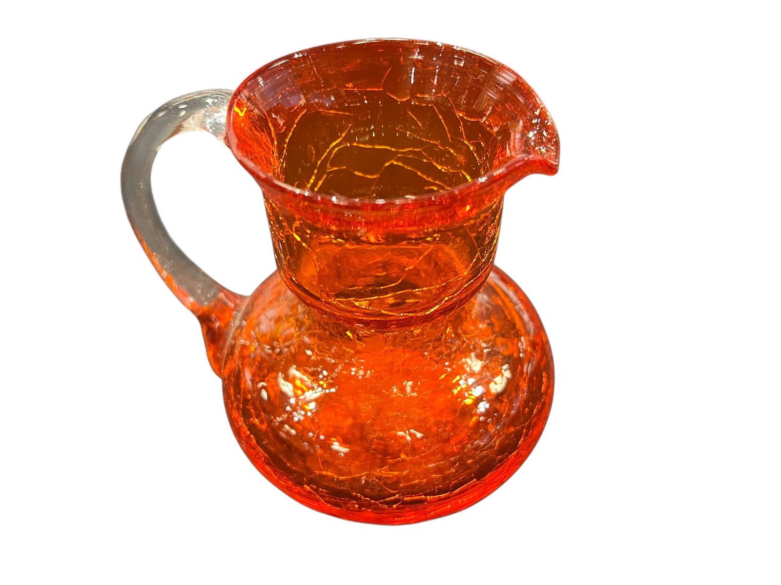 vintage orange crackle glass pitcher: This is a vintage orange crackle glass pitcher, possibly produced by Pilgrim or Blenko Glass. [1, 2]It features a vibrant orange or "tangerine" color with a distinctive crackled texture created by plu