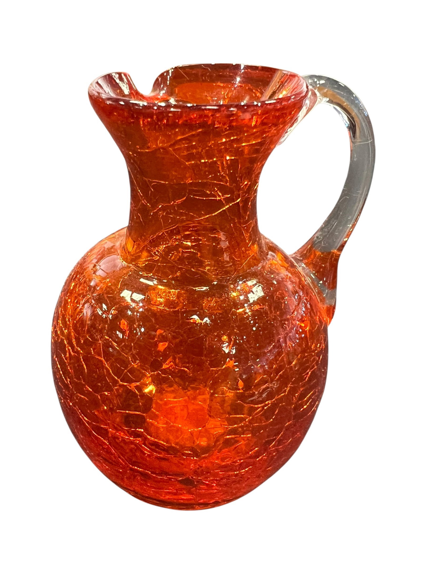 vintage Blenko handblown art glass handled pitcher: This is a vintage Blenko handblown art glass handled pitcher featuring a vibrant tangerine orange crackle finish. [1, 2]Production Style: This piece features a distinct "crackle" texture, created by d