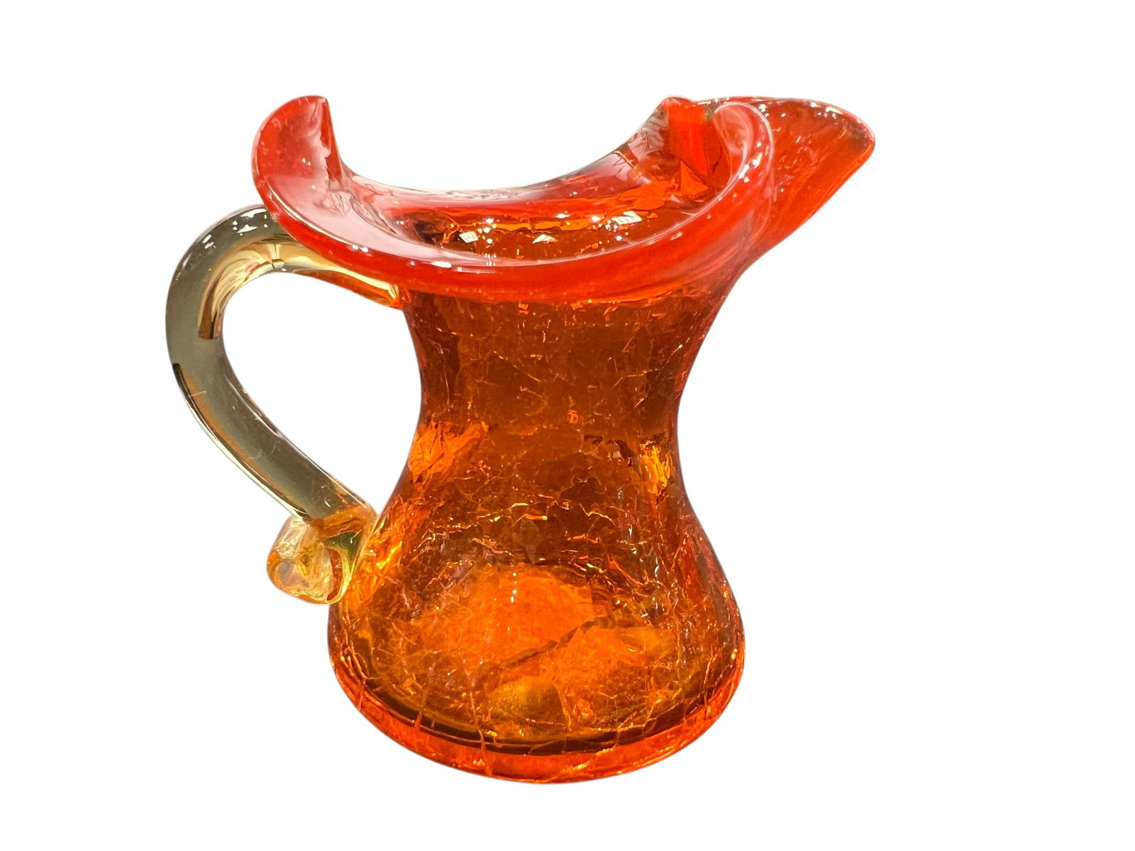 vintage Amberina crackle glass pitcher: This is a vintage Amberina crackle glass pitcher featuring a vibrant orange-to-yellow gradient, a ruffled spout, and an applied handle. [1, 2]Manufacturing Style: The piece is crafted using a hand-blo